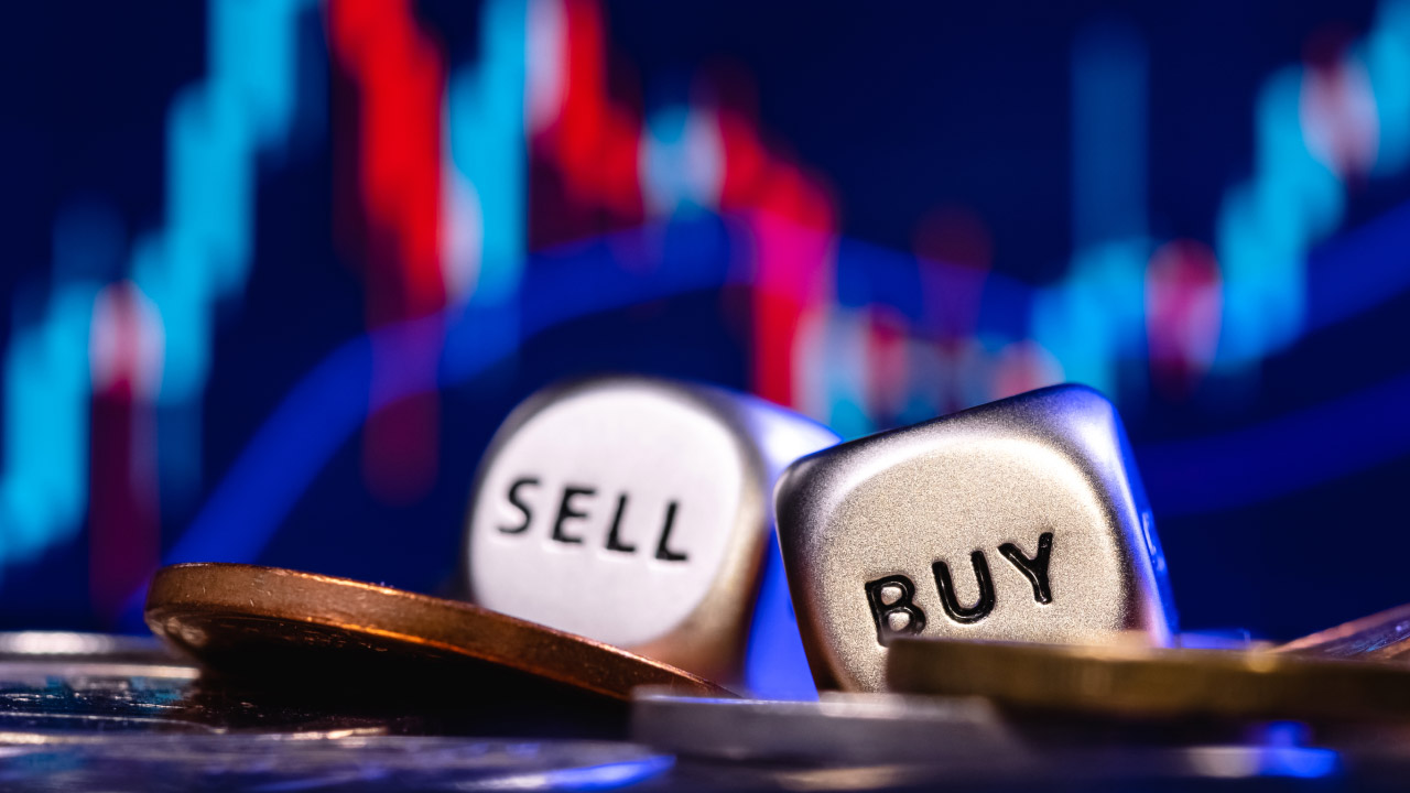 How and When to Buy or Sell in Forex Trading – A close-up of metallic dice labeled 'BUY' and 'SELL' placed among coins, with a blurred candlestick chart in the background, symbolizing key forex trading decisions.