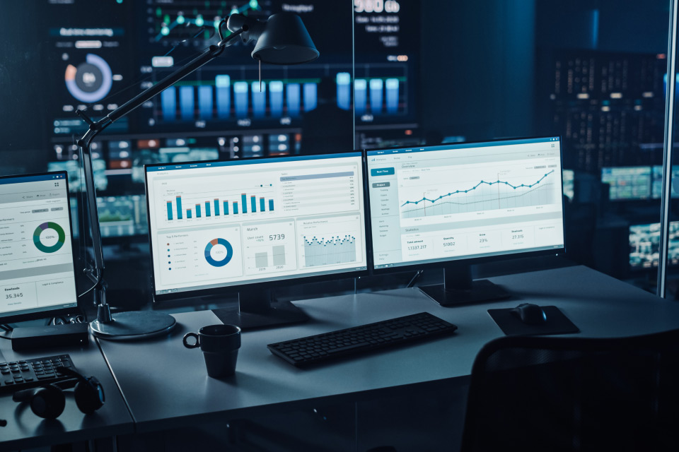 A Comprehensive Guide to Using Demo Accounts + Top Tips illustrated by a trading workstation setup with multiple monitors displaying financial charts.