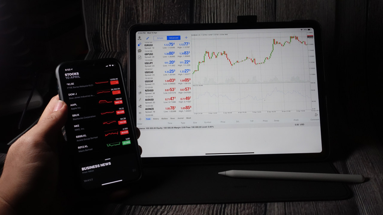 a person holding a smartphone displaying stock market data