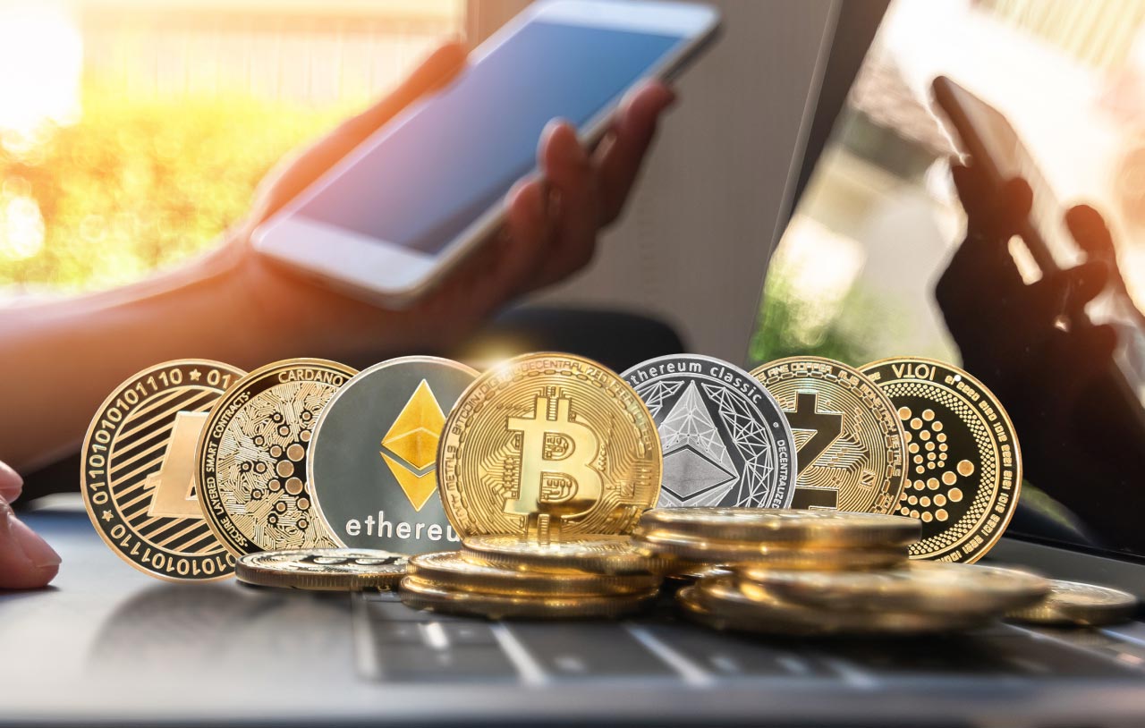 Crypto Day Trading: Top Strategies various popular cryptocurrency coins, including Bitcoin, Ethereum, Litecoin, Cardano, and others, placed on a laptop keyboard, symbolizing active crypto trading.