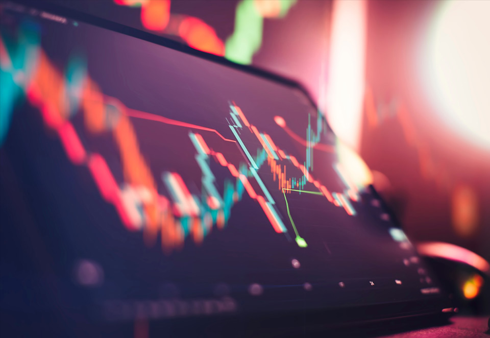 A tablet screen displaying a dynamic financial chart with fluctuating candlestick patterns, highlighting market trends and volatility. This visual aligns with the discussion on the 'Advantages and Disadvantages of Trading Seasonal Patterns,' helping traders evaluate the risks and opportunities in seasonal market movements.