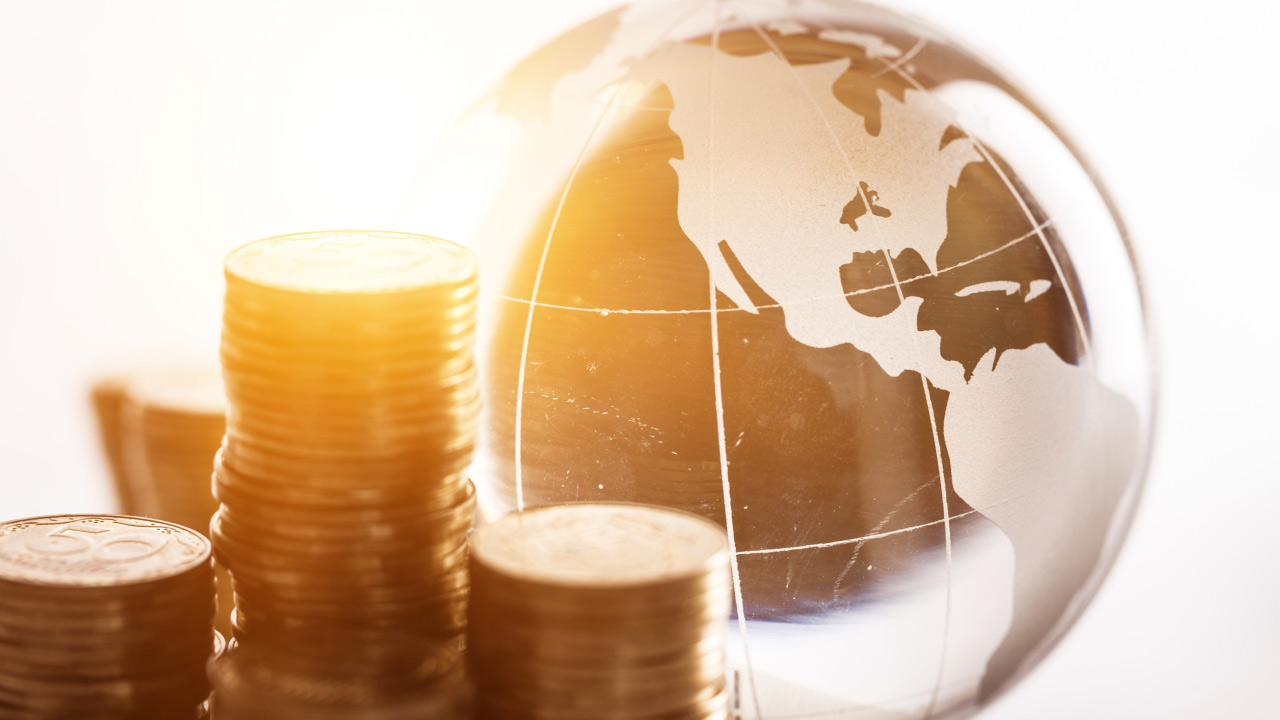 stacks of coins are placed beside a transparent globe,