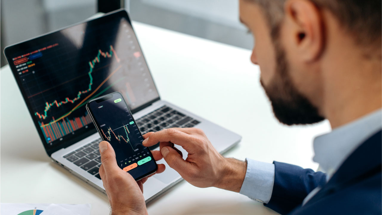 Is MetaTrader 4 Good For Beginners? — A computer screen and mobile phone displaying a financial trading platform interface, highlighting MetaTrader 4’s accessibility for new traders.