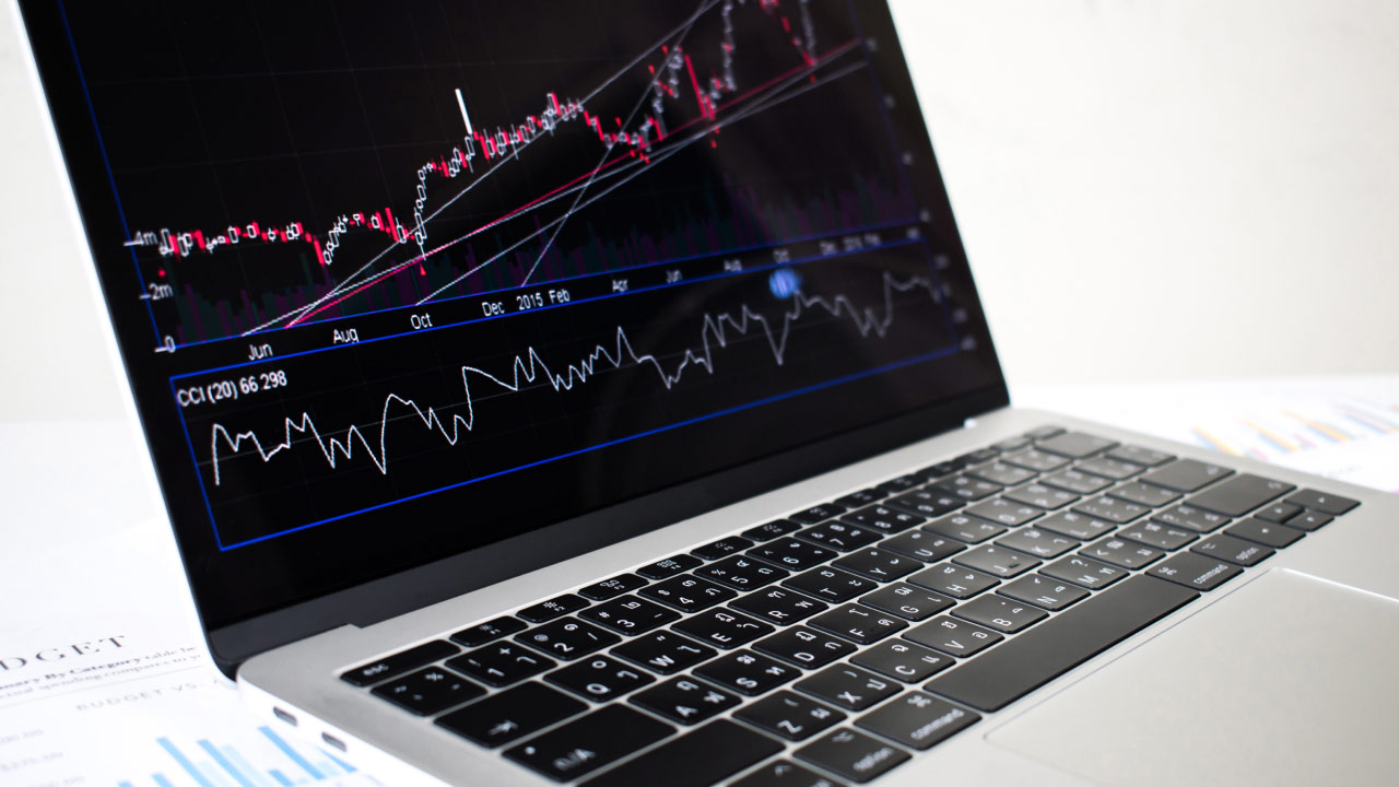 a laptop displaying a detailed trading chart with candlestick pattern &  trend lines