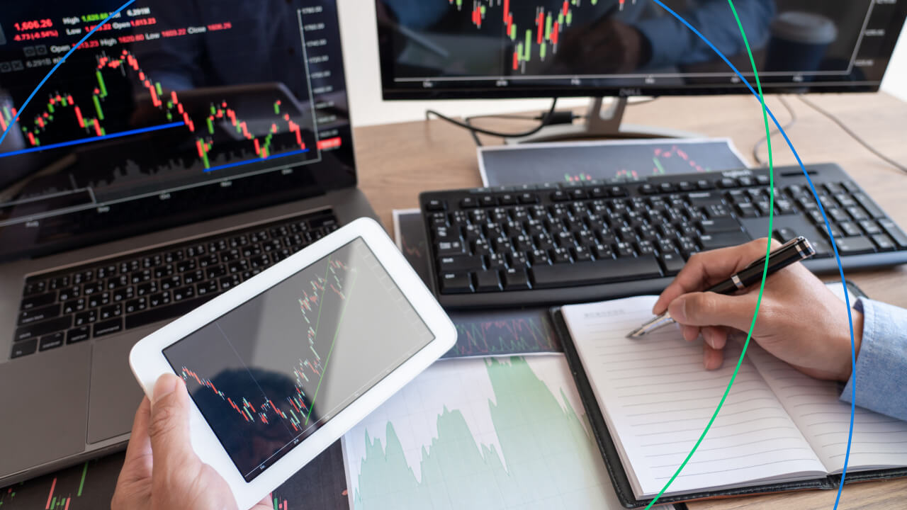 a trading setup with multiple screens displaying candlestick charts and market data