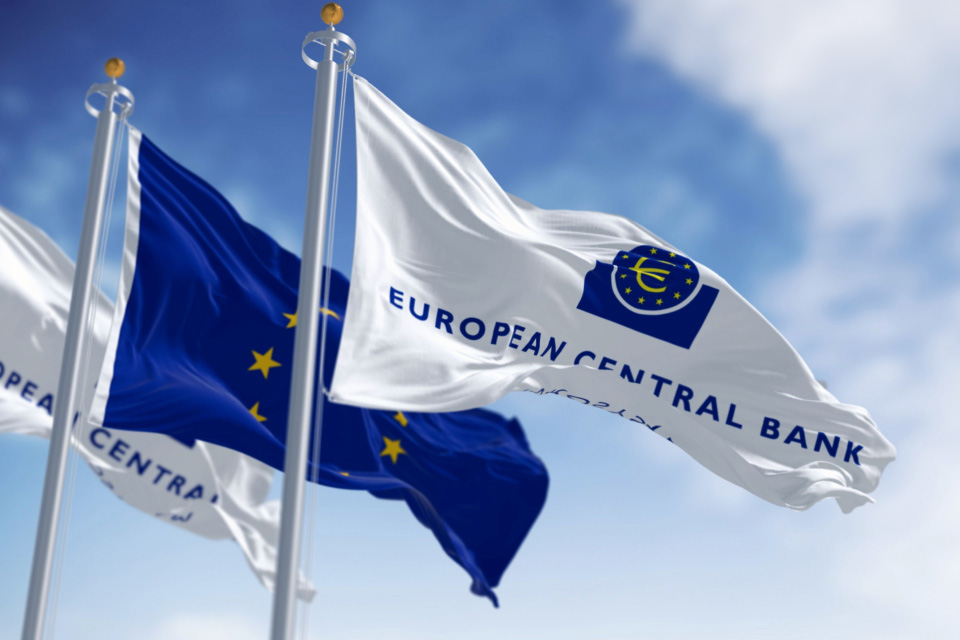 Flags of the European Central Bank (ECB) and the European Union waving against a blue sky, illustrating "How to Trade the ECB Rate Decision."