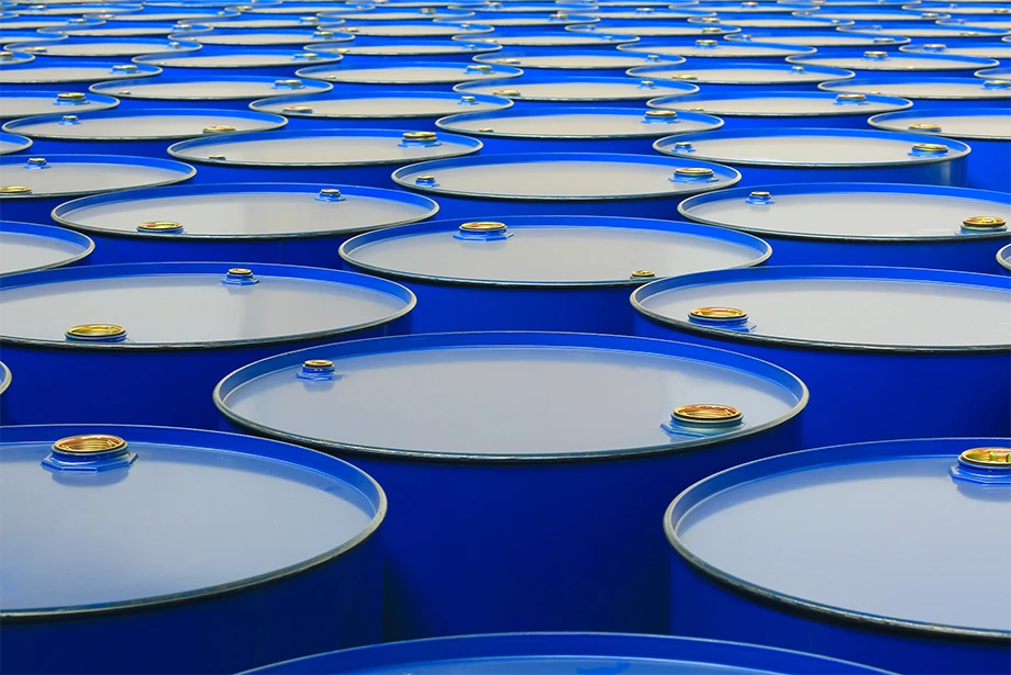 blue industrial barrels used for storing crude oil, representing global oil supply and commodity trading