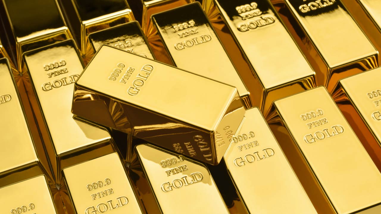 Stacked gold bars with "999.9 FINE GOLD" inscriptions, illustrating "Gold Makes New Highs."