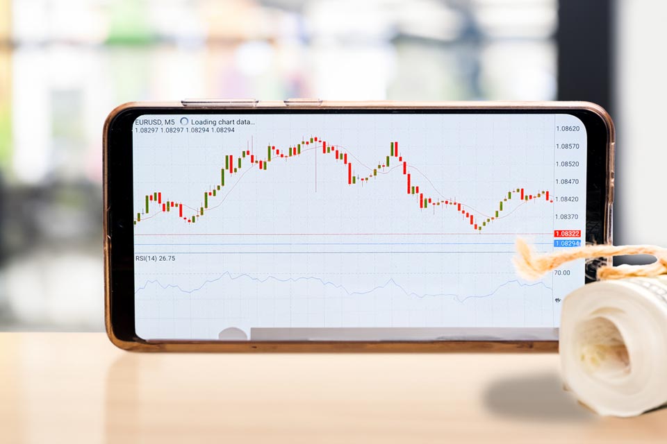 a smartphone displaying a candlestick chart with RSI indicator for EUR/USD trading