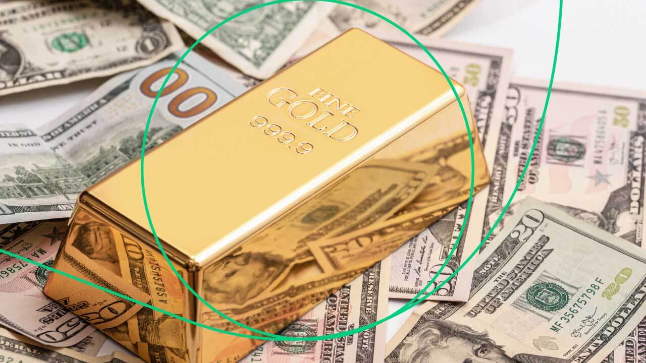 gold bar on a background of dollar bills