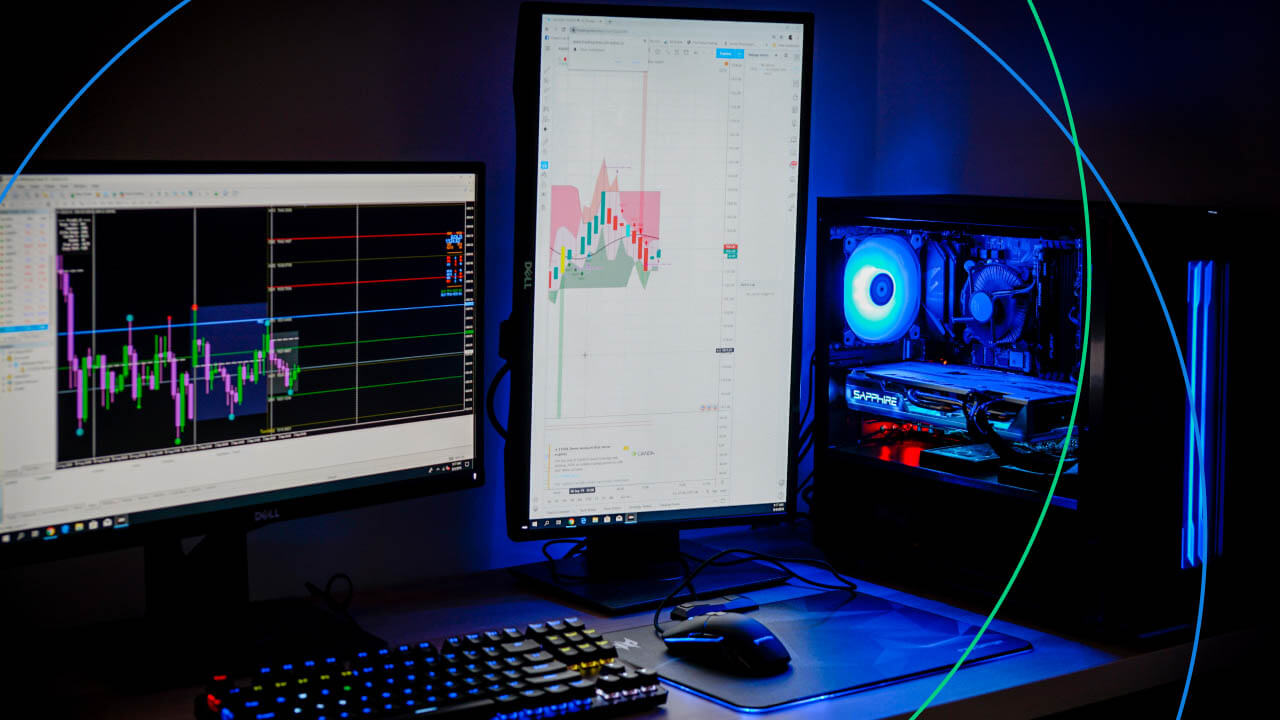  dual computer monitors displaying forex trading charts with a gaming PC setup