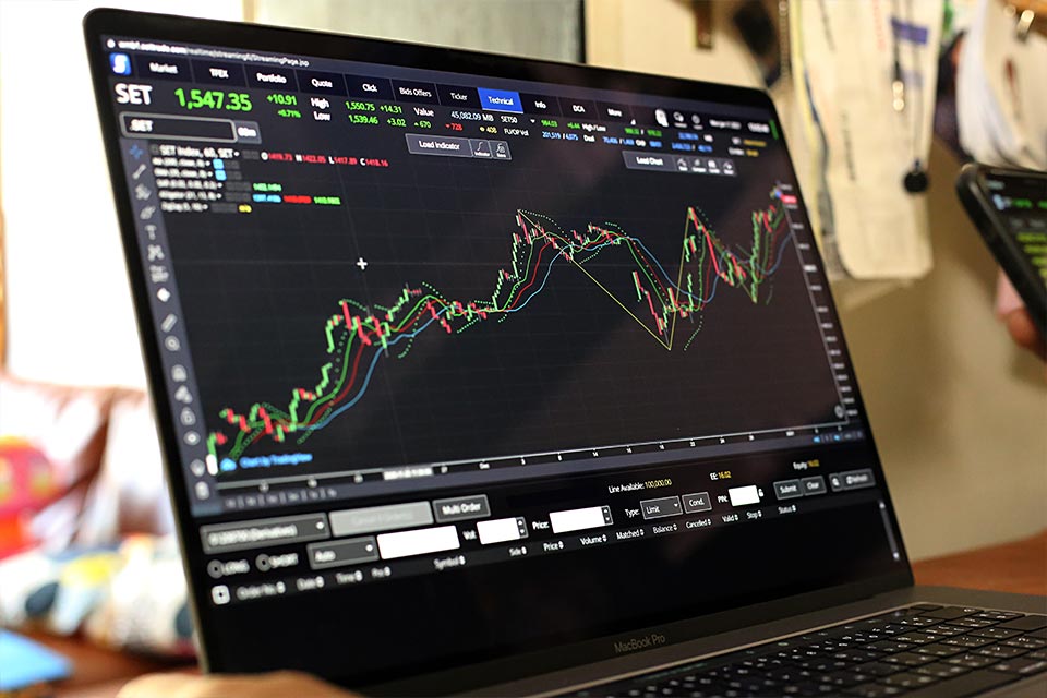 close-up view of a laptop displaying a trading platform with candlestick charts