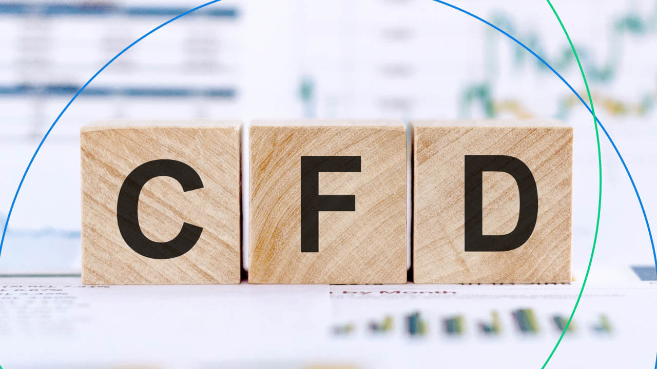 Wooden blocks displaying the letters CFD, representing Contracts for Difference, placed on a reflective surface with a blurred financial chart in the background—illustrating the concept of How to Choose a CFD Trading Platform.