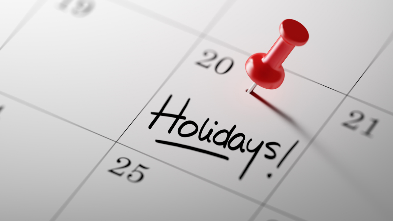 Calendar with a red pushpin marking a holiday, illustrating the impact of bank holidays on trading prices, titled “How do Bank Holidays Affect Trading Prices?”