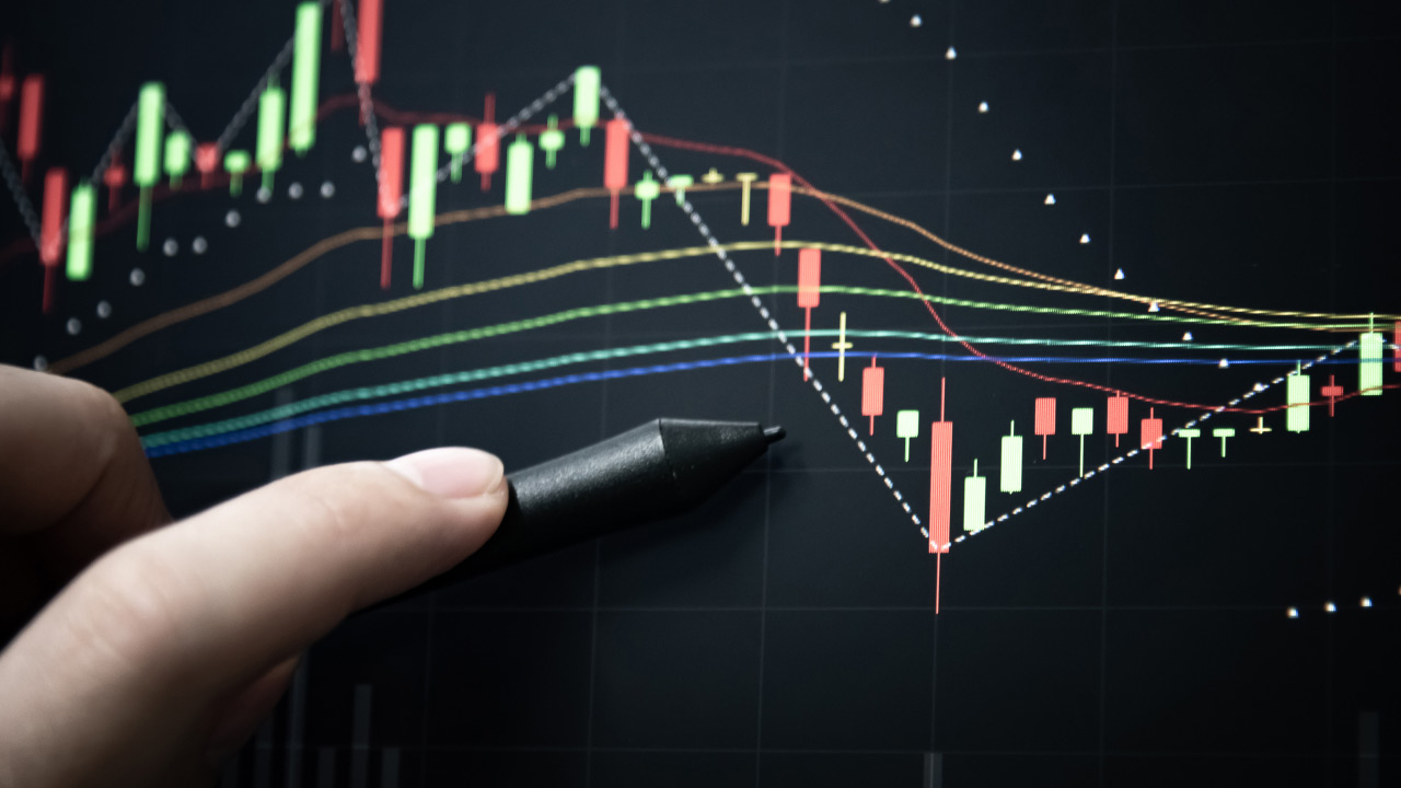 An image titled "5 Key Strategies for Advanced Technical Analysis" showing a close-up of a hand holding a stylus pointing at a candlestick chart on a digital trading screen.