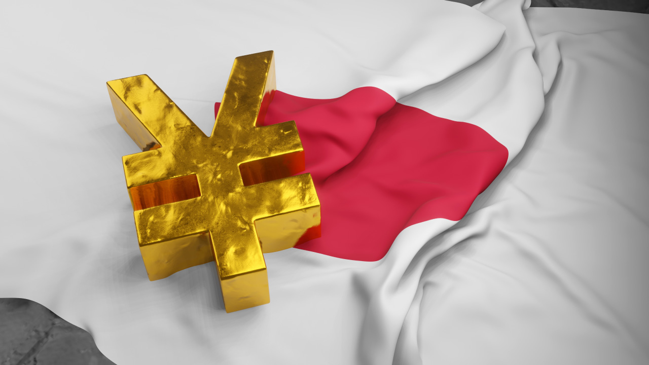 a large golden yen symbol sits on top of a crumpled Japanese flag