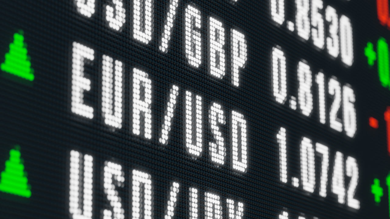 A digital forex display board showing currency pairs and exchange rates including USD/GBP, EUR/USD, and USD/JPY with green and red arrows indicating price movement directions, illustrating how bond yields affect currency movements in forex.