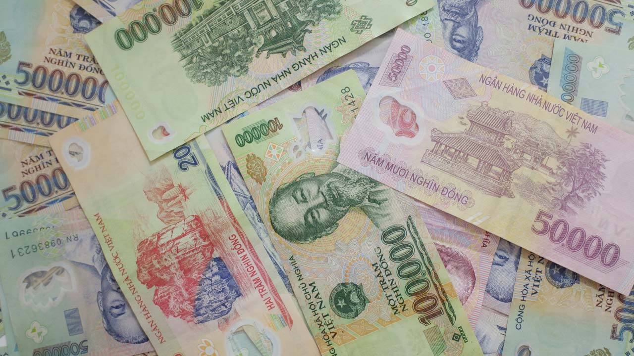 An image titled "5 Guides for Exchanging Foreign Currency to Vietnamese Dong Without Getting Scammed" featuring a scattered collection of Vietnamese đồng banknotes in various denominations.
