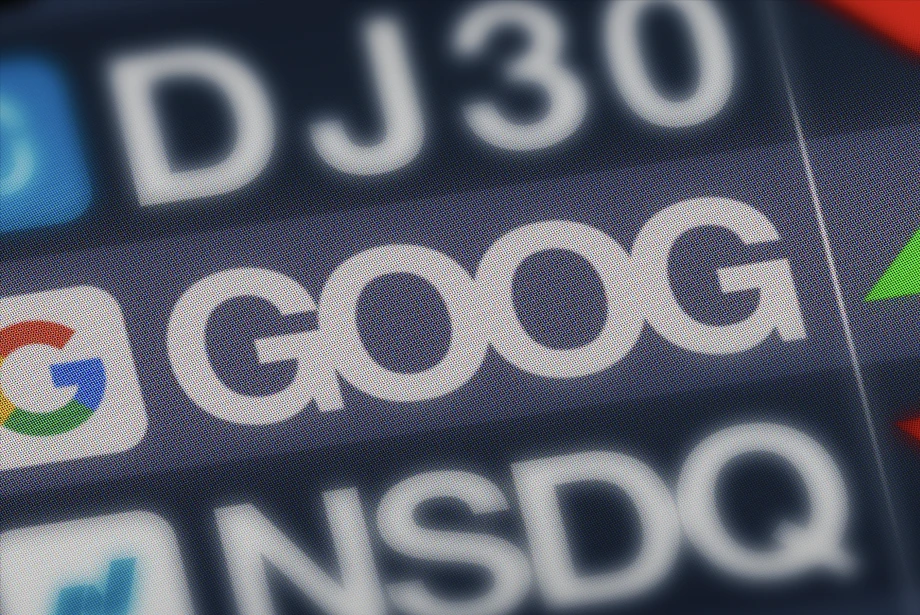 close-up of a digital stock market display showing the Google (GOOG) ticker symbol alongside DJ30 and NSDQ listings