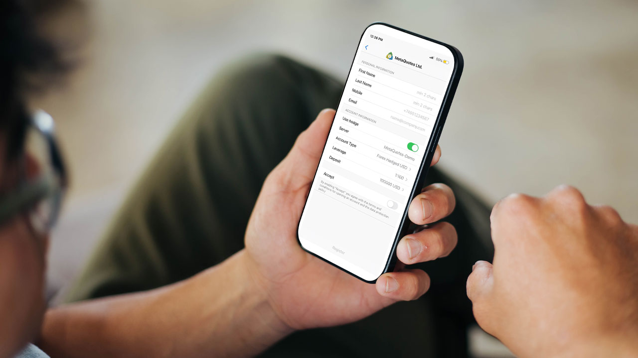 A person holding a smartphone displaying the MetaTrader 5 (MT5) demo account registration screen, showing the process of how to create a demo account on MT5 for simulated trading.