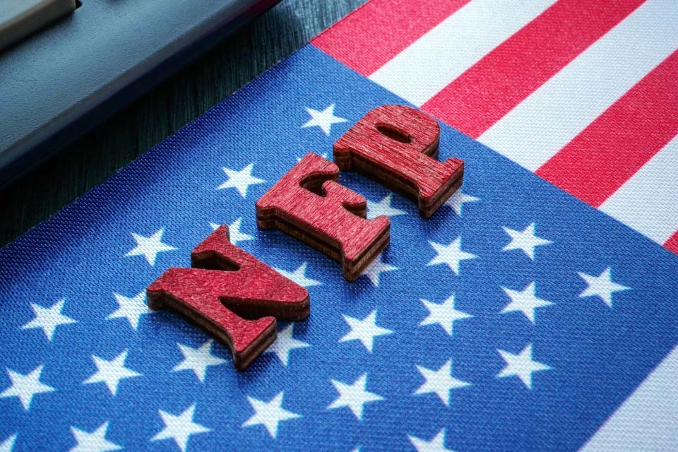 Forex Week Ahead Analysis: 3rd March with wooden letters spelling 'NFP' placed on an American flag, symbolizing the U.S. Non-Farm Payroll report, a key event in the week’s Forex outlook.