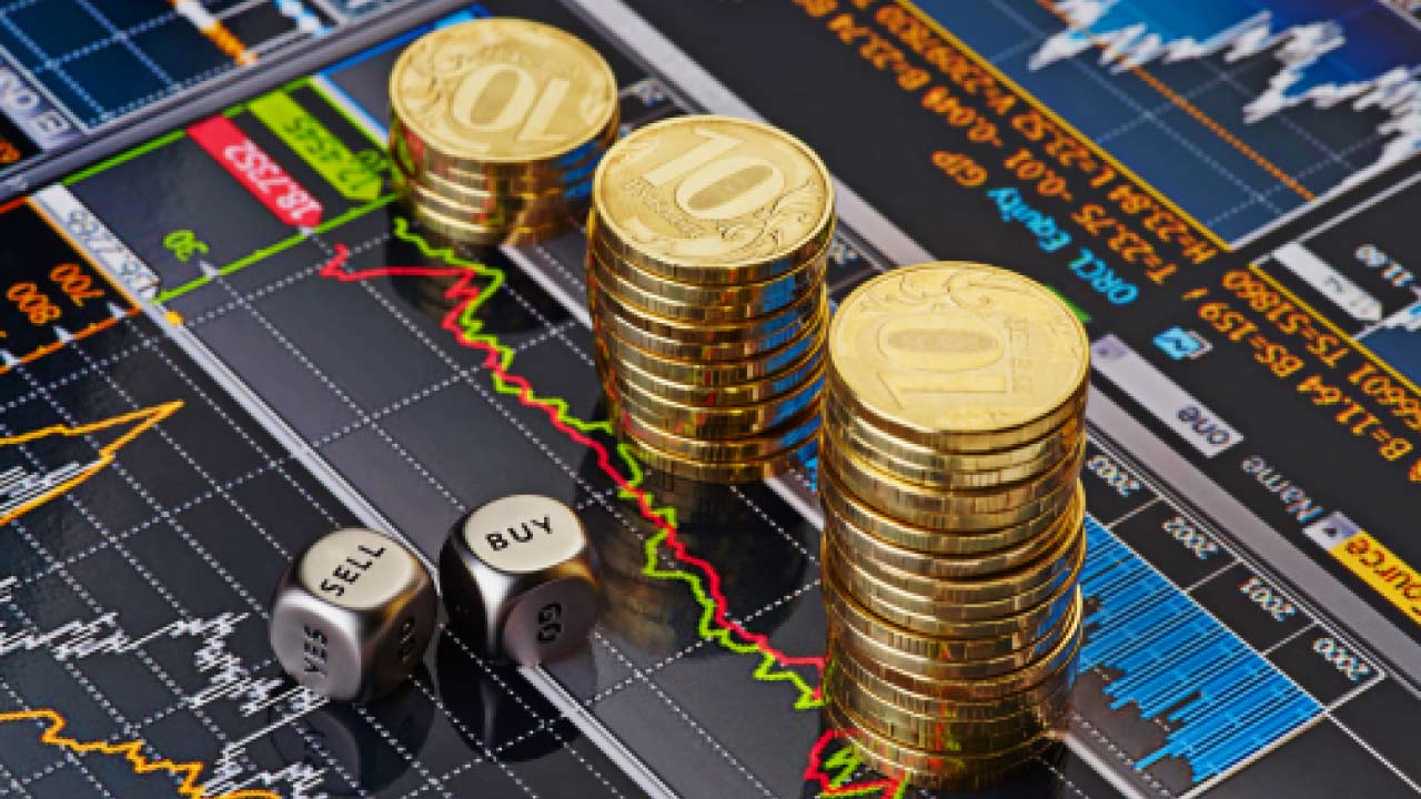 Different coins displayed alongside buy and sell indicators on a computer screen showing charts and graphs, illustrating the use of VPS for Forex trading.